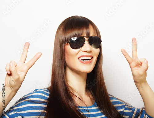 Happy smiling beautiful young woman showing two fingers or victo photo