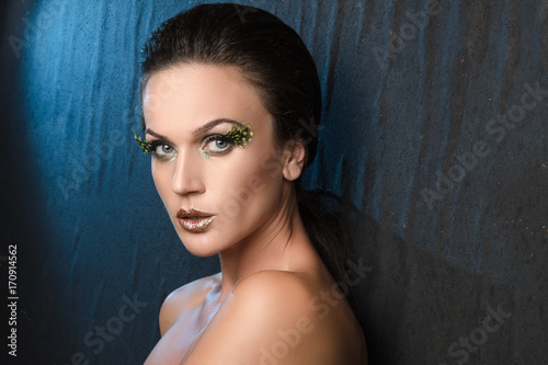 beauty portrait of a woman on the background fabric, blue backlight.