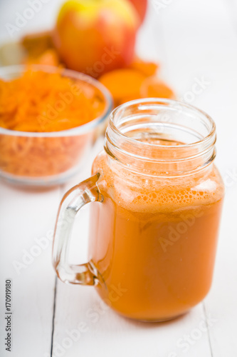 Apple-carrot juice on a wooden table.