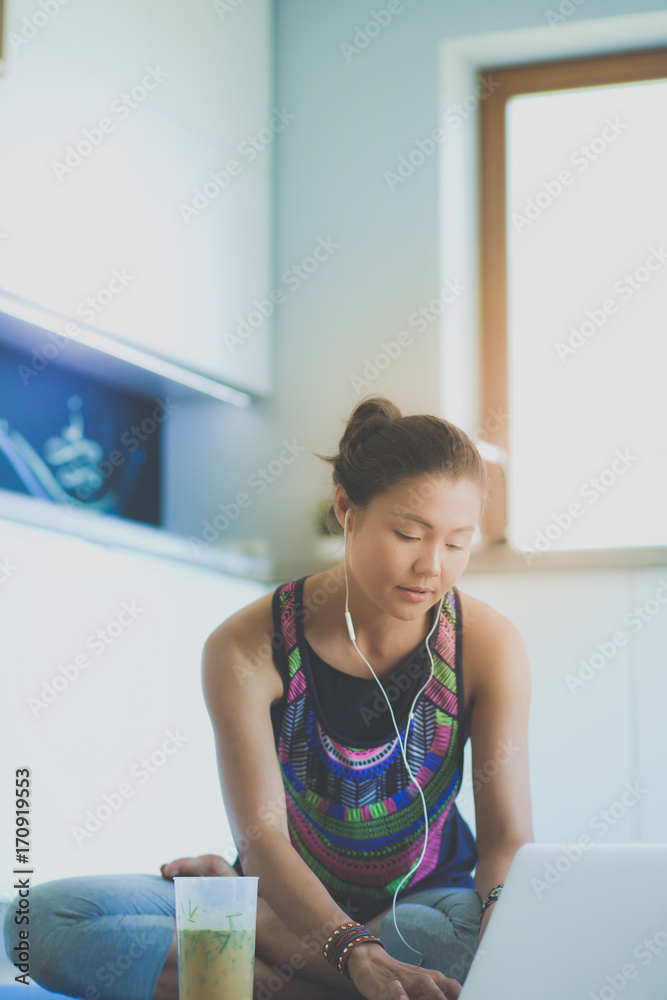 Sporty smiling woman using laptop in bright room. Woman. Lifestyle