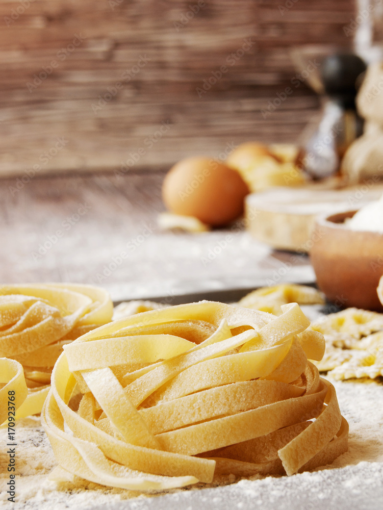 Uncooked pasta with flour on the table, selective focus