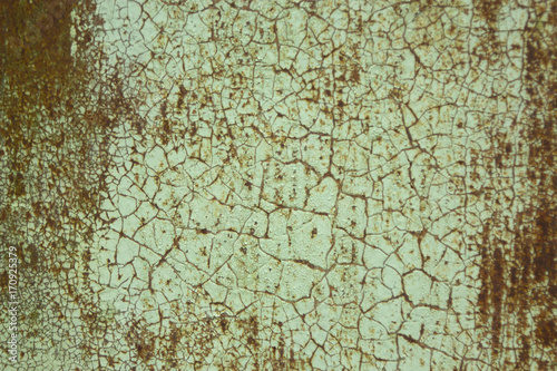 Rusty metallic surface covered with old cracked paint