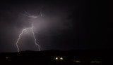 Lightning strike over mountain range with clouds
