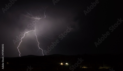 Lightning strike over mountain range with clouds