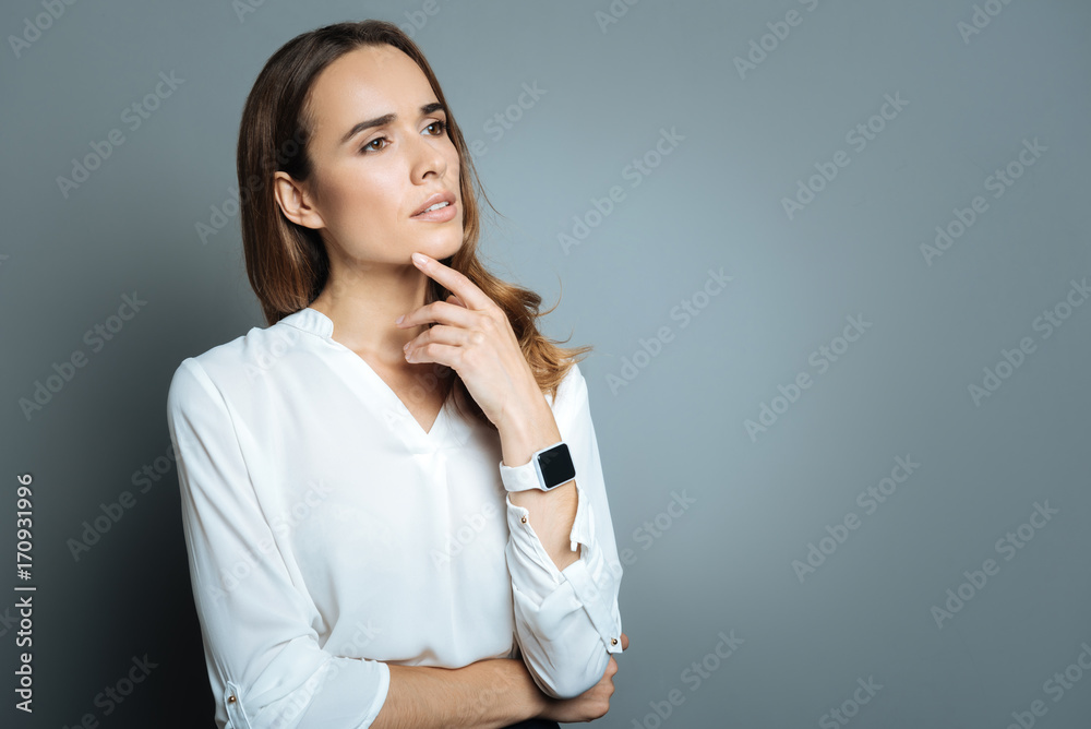 Attractive thoughtful woman pressing a finger to her chin Attractive thoughtful woman pressing a finger to her chin