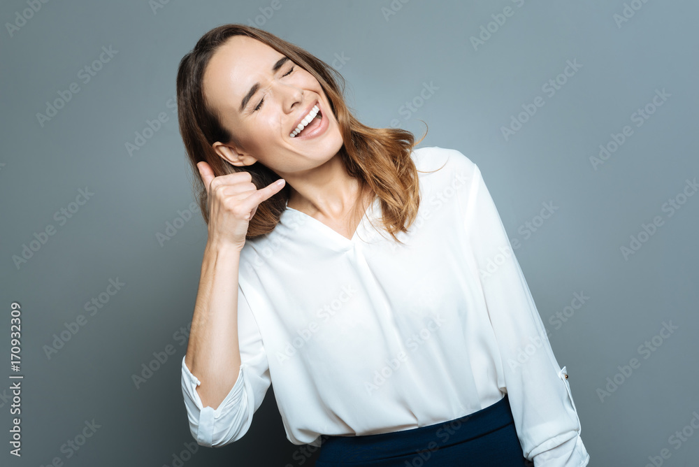 Happy cheerful woman pretending to make a call Happy cheerful woman pretending to make a call