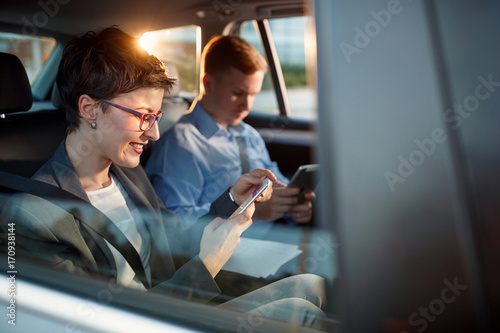 smiling business woman calling smartphone number in car.
