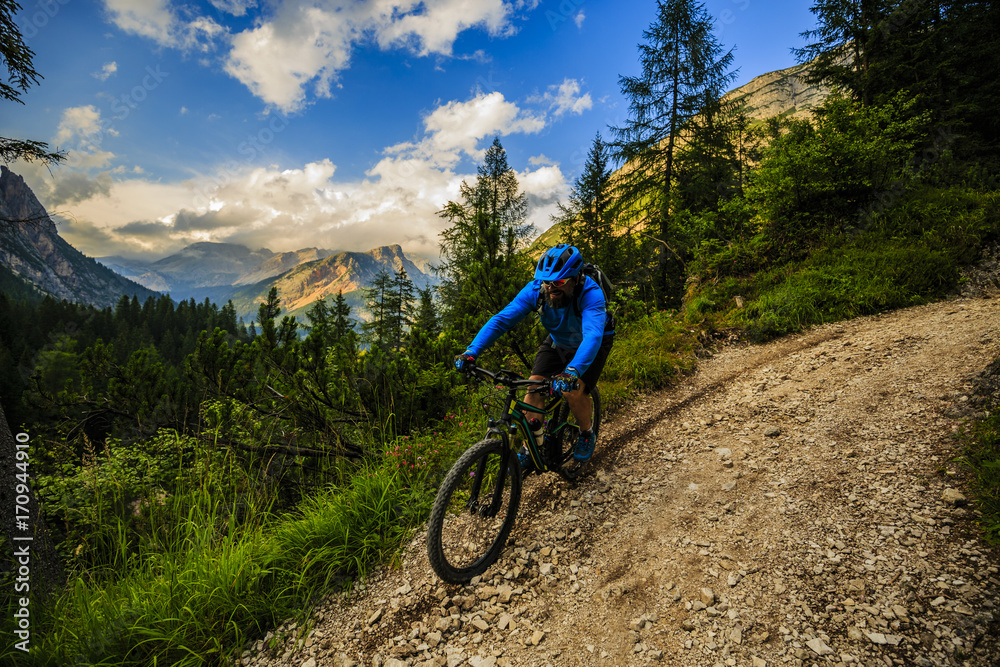 Cycling, View of cyclist riding mountain bike on single trail in Dolomites,  South Tirol, Italy
