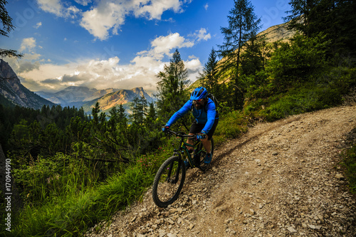 Cycling, View of cyclist riding mountain bike on single trail in Dolomites, South Tirol, Italy