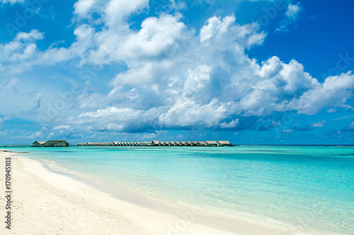 Beautiful tropical landscape - sandy beach and wooden villas over Indian ocean, Maldives island