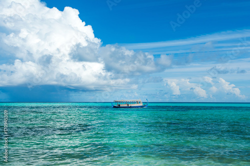 Wooden Maldivian traditional dhoni boat at sunny day on the turquoise Indian ocean water, Maldives © Myroslava