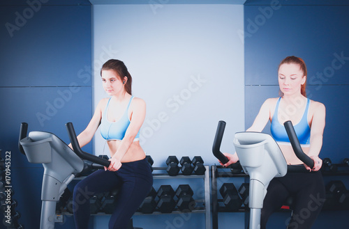 Group of people at the gym exercising on cross trainers. people at the gym photo