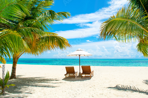 Beautiful sandy beach with sunbeds and umbrellas in Indian ocean  Maldives island