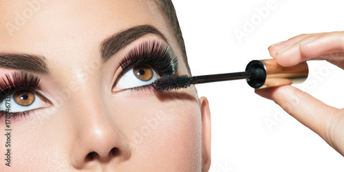 Long lashes closeup. Beautiful woman applying mascara on her eyes. Makeup photo