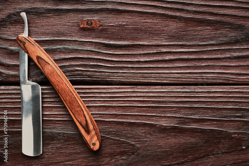 Vintage barber shop straight razor tool on wooden background