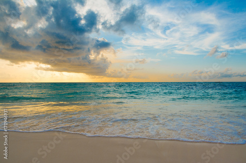 Landscape of beautiful sunset in Maldives island sandy beach with colorful sky over wavy sea © Myroslava