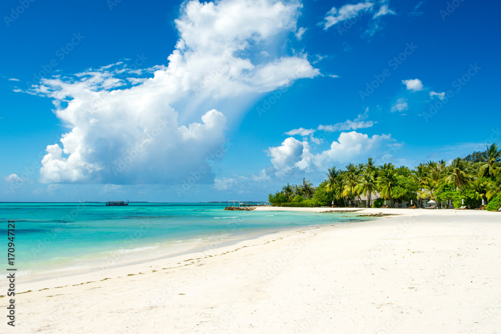 Beautiful sandy beach with sunbeds and umbrellas in Indian ocean, Maldives island