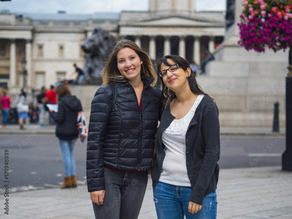 Two girls posing for photo at Trafalgar Square in London