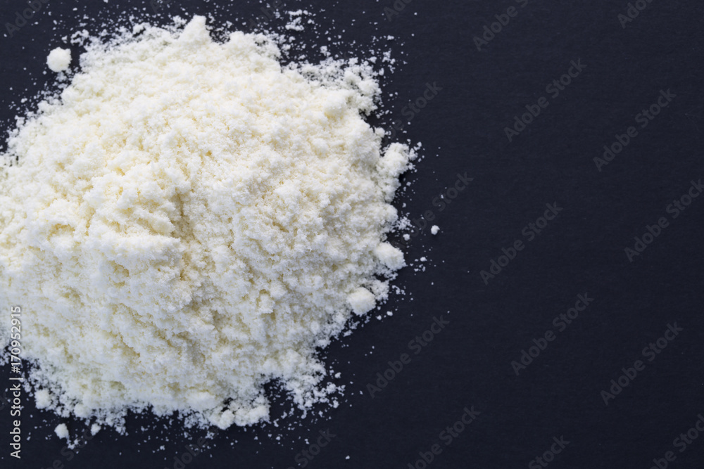 Heap of powdered milk on the black background. Heap of powdered milk on the black background.