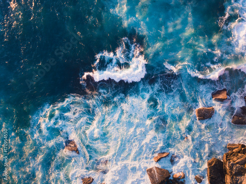 Photography Aerial view of waves and some rocks.