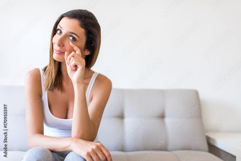 A beautiful but sad woman at home on the sofa A beautiful but sad woman at home on the sofa