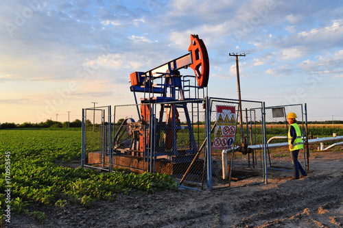 A female engineer at work on an European oil well during dusk time