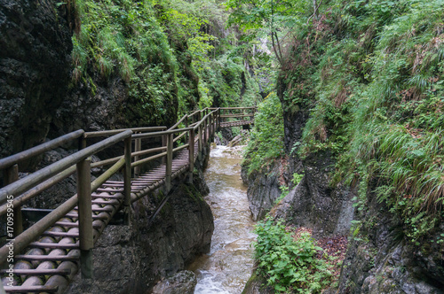 Wooden path running along the cliff and over the river gorge