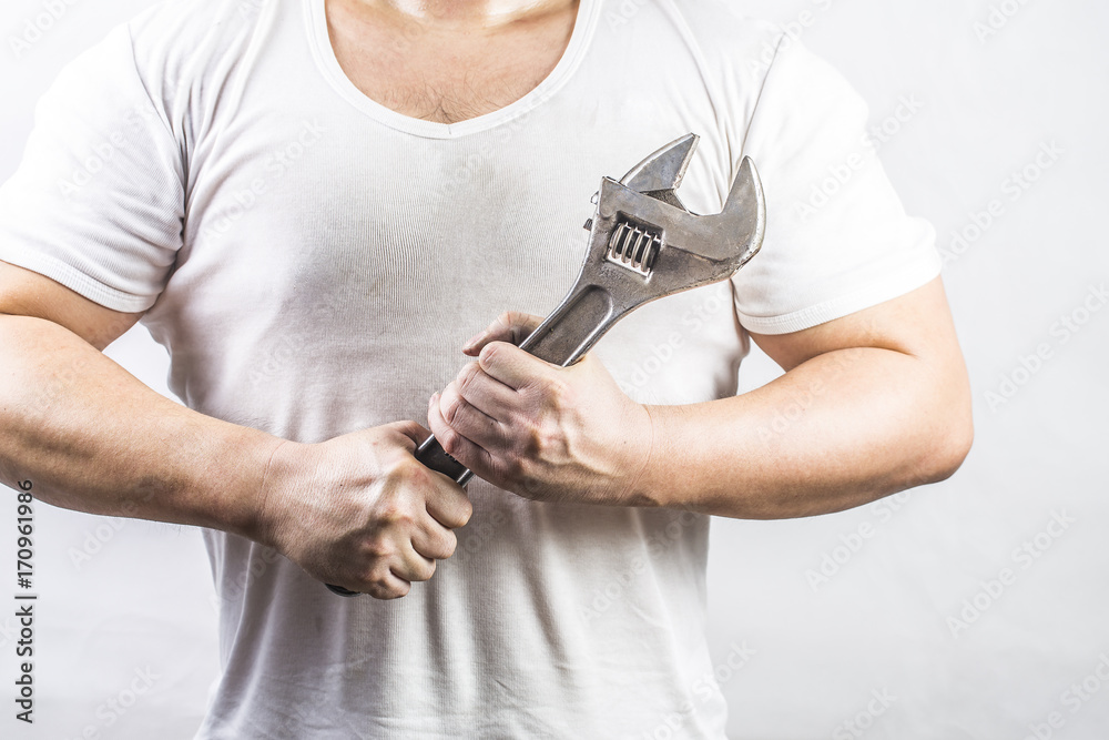 Man holding an adjustable wrench Man holding an adjustable wrench