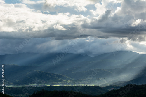 Beautiful sun rays through the clouds over mountains,evening light,Amazing scene © 9kwan