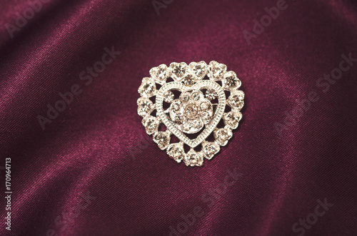 Brooch silver heart with diamonds on silk fabric