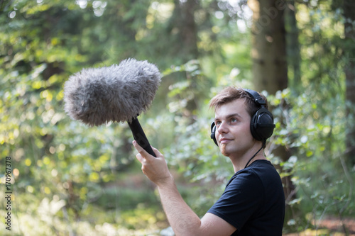 Tontechniker mit Kopfhörer und Mikrofon, draußen photo