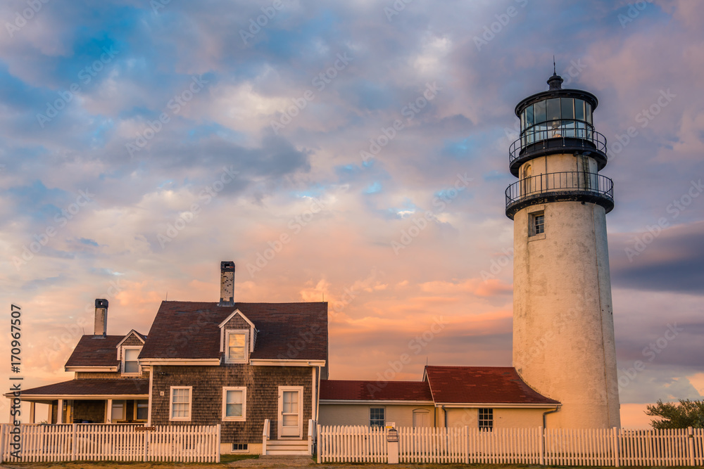 Cape Cod lighthouse and light keeper's house at sunset against beautiful sky 