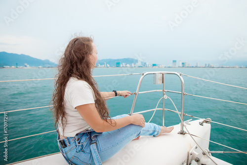 Young woman looking at the ocean while sitting on yacht