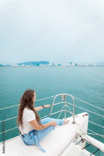 Young woman looking at the seawhile sitting on a boat © zulman