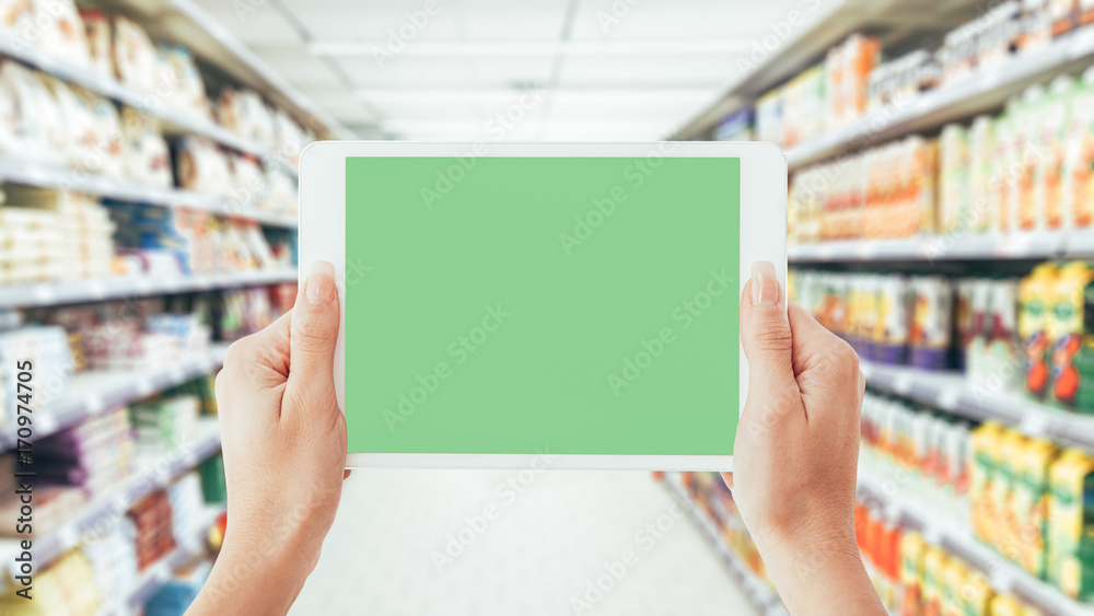 Woman using a tablet at the supermarket Woman using a tablet at the supermarket