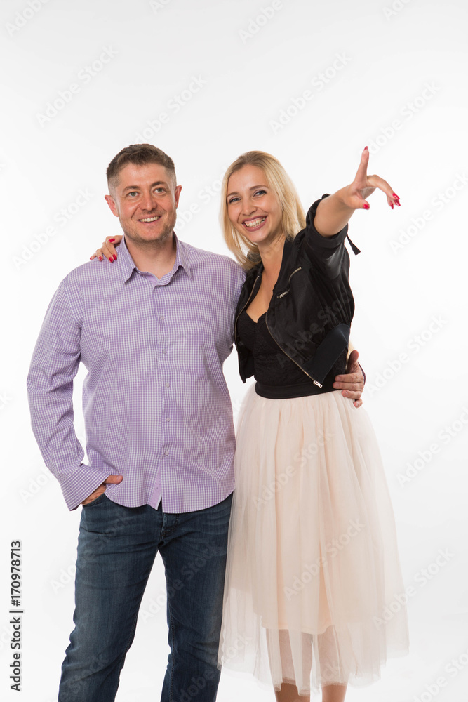 Young happy woman portrait of a confident businesswoman showing by hands on a gray background. Ideal for banners, registration forms, presentation, landings, presenting concept. Young happy woman portrait of a confident businesswoman showing by hands on a gray background. Ideal for banners, registration forms, presentation, landings, presenting concept.