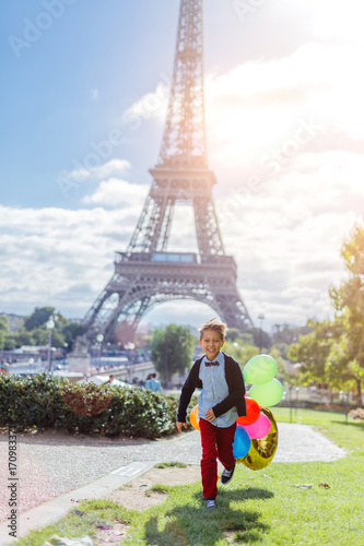 Boy with bunch of colorful balloons in Paris near the Eiffel tower. © Max Topchii