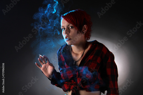 Eine junge Frau raucht Zigarette und blickt erschrocken