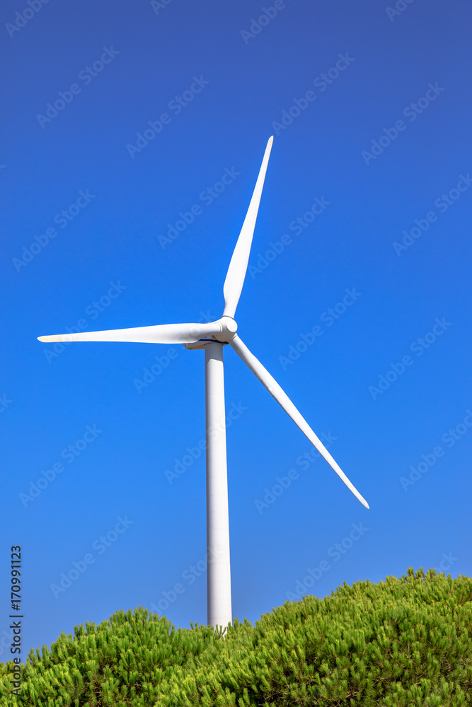 One Wind Turbine, alternative energy source. Sagres, Algarve, Portugal of wind turbine rotating. Alternative energy, renewable energy and environmental sustainability. Sunny day in blue sky. One Wind Turbine, alternative energy source. Sagres, Algarve, Portugal of wind turbine rotating. Alternative energy, renewable energy and environmental sustainability. Sunny day in blue sky.