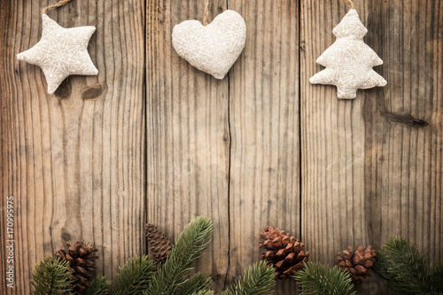 Christmas background - fir leaves and pine cones decorating rustic elements on vintage wood table. Creative Flat layout and top view composition with border and copy space design.