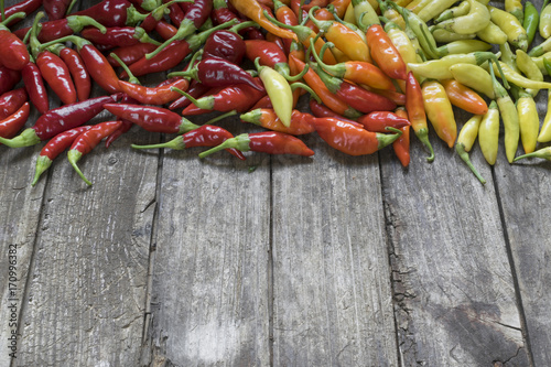 Colorful hot chilli peppers on wooden table with copy space