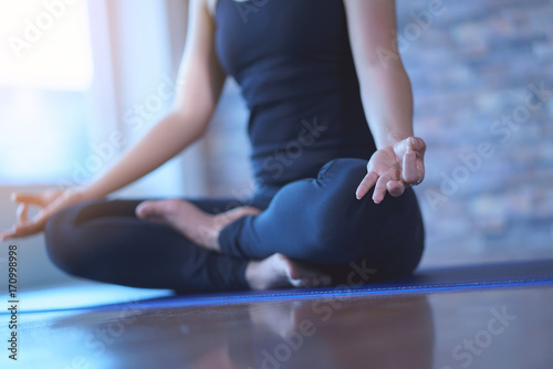 Close up view of young woman meditates while practicing yoga in a studio. Freedom concept. Calmness and relax,