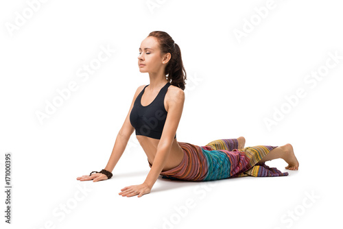 Slim girl doing yoga indoors isolated on white