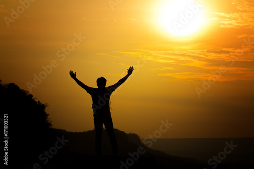 silhouette of man travel show arm up for achievements successful and celebrating success with sunrise