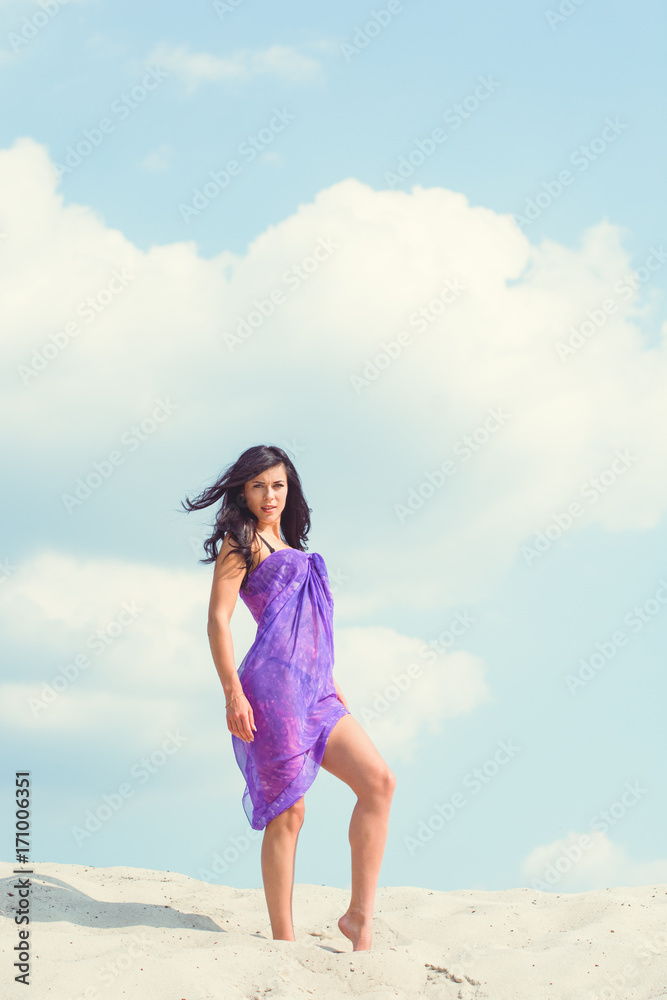 A girl on the beach, rest and relaxes in the sand dunes of the sand. Pretty woman demonstrates a good figure and herself. The concept of a beautiful vacation and beauty of body and soul A girl on the beach, rest and relaxes in the sand dunes of the sand. Pretty woman demonstrates a good figure and herself. The concept of a beautiful vacation and beauty of body and soul