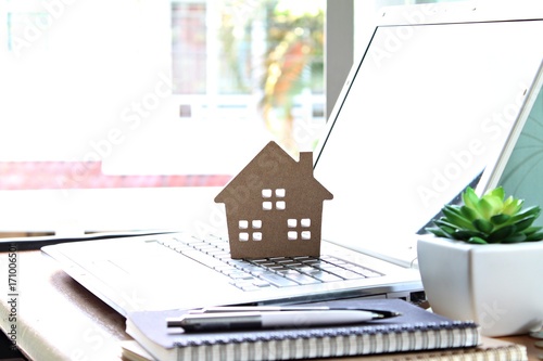 Business, finance, savings, property ladder or mortgage loan concept : Wood house model on computer laptop