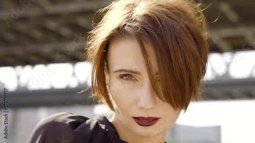 close-up shot of a pretty woman with short red hair and mysterious smile
