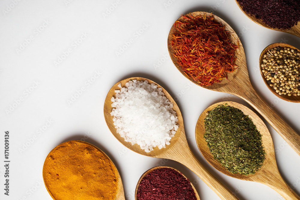 Spices in wooden spoons isolated on white background Spices in wooden spoons isolated on white background