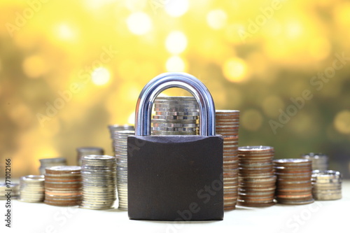 Coin money stack and lock, on gold light background. Saving and financial security concept.
