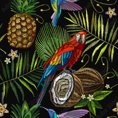 Embroidery parrot, humming bird, palm tree leaves, pineapple, coconut tropical seamless pattern. Fashionable embroidery tropical summer background. Template for design of clothes